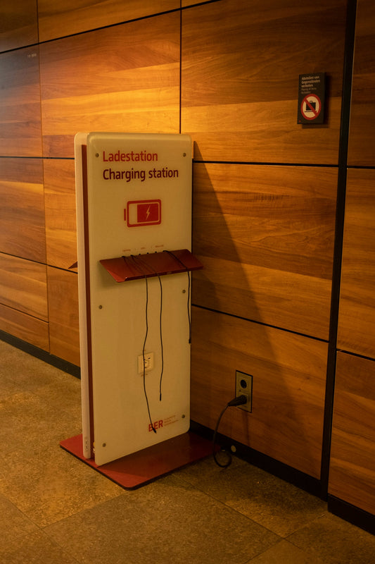 a red and white charging station next to a wooden wall